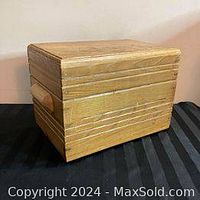Side view of the vintage wooden storage box showing handle and wood grain