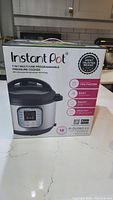 Front view of the Instant Pot box showing product name, model, and key features such as 7-in-1 functionality.