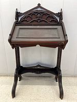 Front view of the desk showing carved wood details and closed slant-top lid with lock.