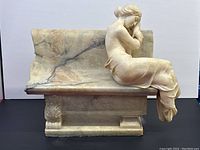 Front view of entire sculpture showing maiden and bench