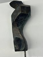 Front view of bronze abstract sculpture on white background showing overall form and patina