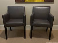 Pair of grey leather armchairs front view