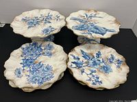 Top view of two cake stands and four plates arranged on black surface