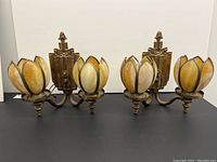 Front view of both wall sconces showing dual tulip shades and decorative backplates