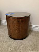 Front view of round wood side table with glass top intact