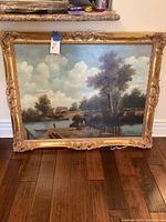 Full front view of framed painting showing carved gilt wood frame and entire lake landscape scene