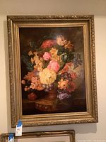 Front view of the large framed painting showing floral arrangement in a vase against a dark background.