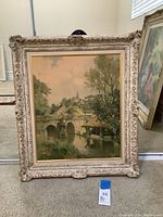 Full view of the framed painting showing the town with bridge and waterway.