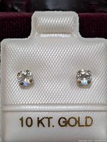 Pair of 10K white gold moonstone stud earrings on display card labeled '10 KT. GOLD'.