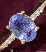 Extreme close-up of oval tanzanite center stone with diamond-set shoulders.