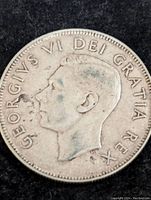 Obverse side of the 1952 Canadian 50 cents silver coin showing King George VI profile and inscription.