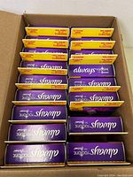 Box containing 17 small boxes of Always Radiant pads arranged in a cardboard shipping container.