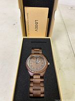 Front view of LeeEv wooden watch with Roman numeral dial in original box with foam insert and documentation visible.