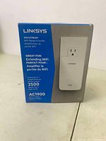 Box front showing Linksys Max-Stream WiFi Range Extender AC1900 model, with coverage area and speed details.