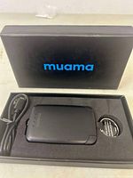 Muama Mini Power Bank with USB cable and key ring in black box packaging.