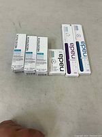 Photo showing three boxes of NeoStrata Reactivate Skin Neutralizing Serum and two Nada toothbrushes, one purple and one blue, plus a pack of four brush heads.