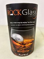 Photo of packaging showing the product 'On The Rock Glass + Ice Ball' with branding and marketing text indicating it is a new way to enjoy drinks 'on the rocks'.