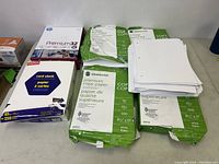 Photo of multiple packs of Grand & Toy branded 3-hole punched premium copy paper and an opened pack of printing paper sheets.