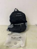 Black Zomake backpack unfolded showing front with main zip compartments and mesh side pockets