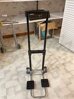 Foldable hand truck with handles and foot plates visible.