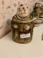 Ceramic monk cookie jar with inscription 'Thou Shalt Not Steal' on the robe, shown assembled on a table.