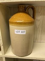 Front view of a ceramic jug with light brown top glaze and cream bottom.