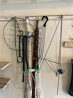 Full view of various bungee cords, macrame plant hangers, wire rack, and wire hangers hanging on a wall