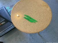 Top view of the round glass table showing the glass top and metal fastener under the glass.