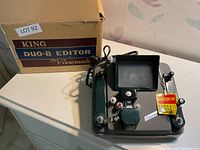 King Duo-8 Viewmate film editor device on a white surface alongside its original cardboard box.