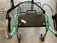 Dolomite walker shot from a diagonal angle showing black padded seat, wheels, and foldable metal frame in light green color.