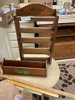 Overall view of the wood wall shelf labeled 'Collectables' with three shelves and smaller detachable box in front, alongside wooden rulers.