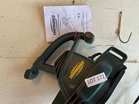 Yardworks electric blower mulcher tool and part of the product manual, front angle showing handle and vents