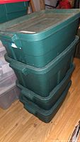 Stack of three green plastic storage bins used for holding the craft supplies