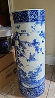 Front view of blue and white porcelain umbrella stand showing bird and floral designs