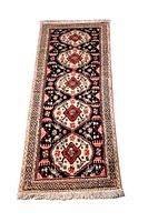 Full view of Persian Ardabil runner rug showing geometric medallions on dark navy background with ornate borders and fringed edges.
