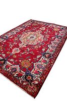 Full view of light red Persian area rug with floral medallion pattern