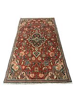 Full view of rectangular oriental floral patterned rug with rust-red base and multicolored blossoms