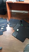 Rubber and carpeted Highlander floor mats spread out on floor under a desk