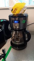 Front view of Black & Decker coffee maker with digital time display set to 3:51, glass carafe on warming plate.