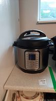 Instant Pot on counter showing full cooker body and lid with handle