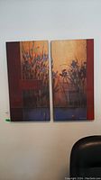 Two canvas wall art pieces hung side by side on a wall, showing floral themes and warm earth tone colors.