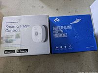 Box of Chamberlain Smart Garage Control device alongside InfutureQIANG wireless headphones box.