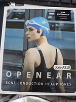 Box front showing model and waterproof rating, and image of a swimmer wearing the headphones.