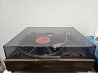 Front view of the vintage Pioneer turntable with wooden base and dust cover, showing a vinyl record on the platter.