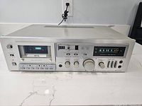 Front view of Sherwood S-8000 CS stereo cassette tape deck showing cassette window, control buttons, knobs, and audio level meters.