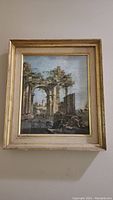 Framed print showing an Italian/Greek architectural scene with ancient arches and columns, in a golden and beige frame.