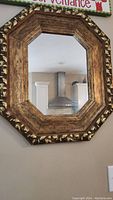 Full view of the octagonal ornate mirror showing its size and frame design.