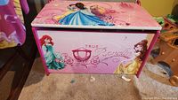 Front view of pink Disney Princess storage chest featuring Ariel and Belle with the text 'True Royalty'.