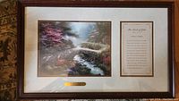 Framed Tom Kinkade painting Bridge Of Faith alongside framed scripture passage titled The Bridge Of Faith.
