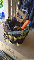 Full view of Kunys Bucket Buddy tool organizer with multiple hand tools packed inside including a hand saw, screwdrivers, and pliers